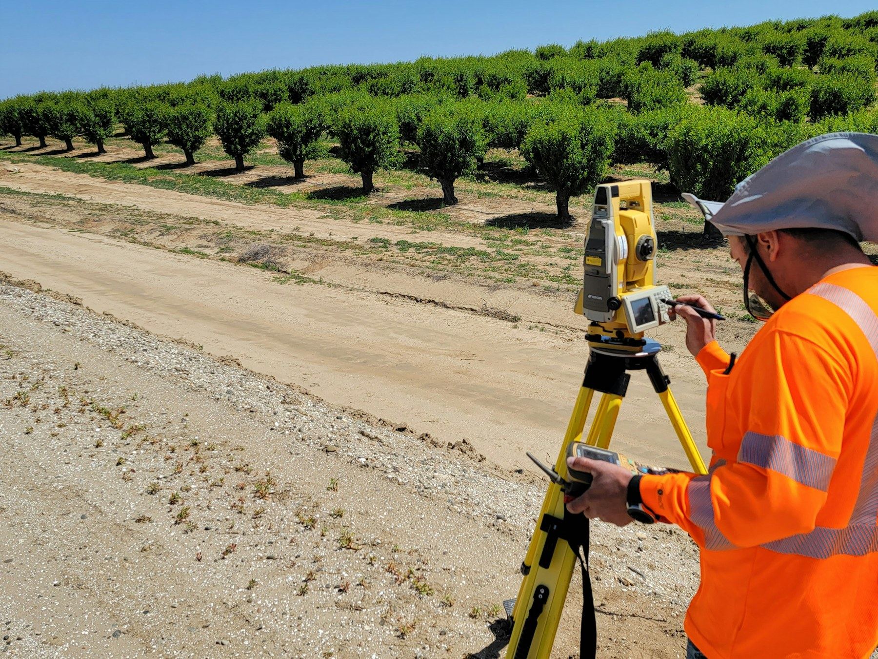 a man in an orange shirt is using a tripod