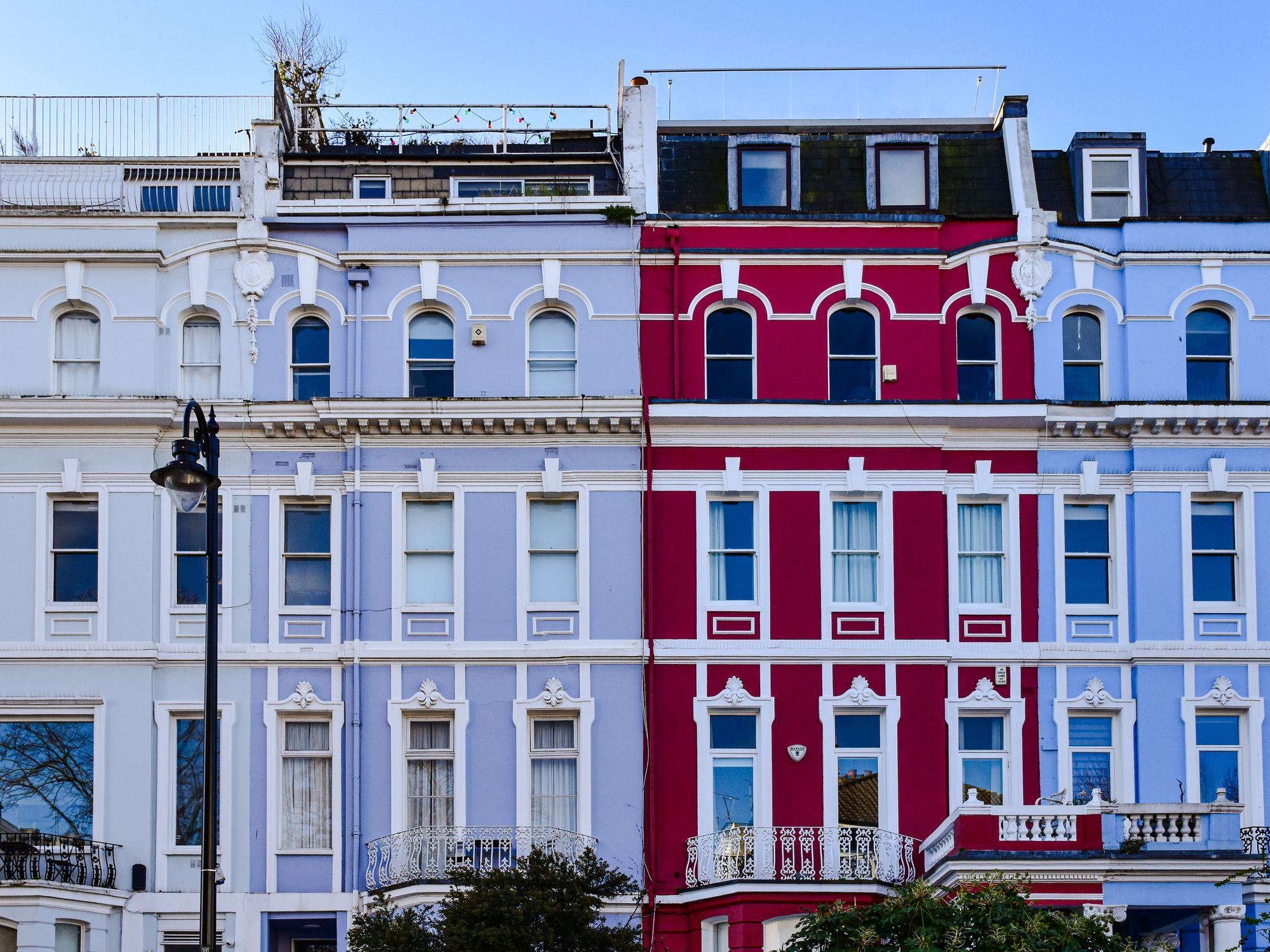 Charming and colorful facade of terraced houses in Notting Hill, London.